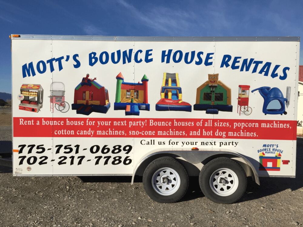 The Mott's Bounce House Rentals trailer with phone numbers painted on the side